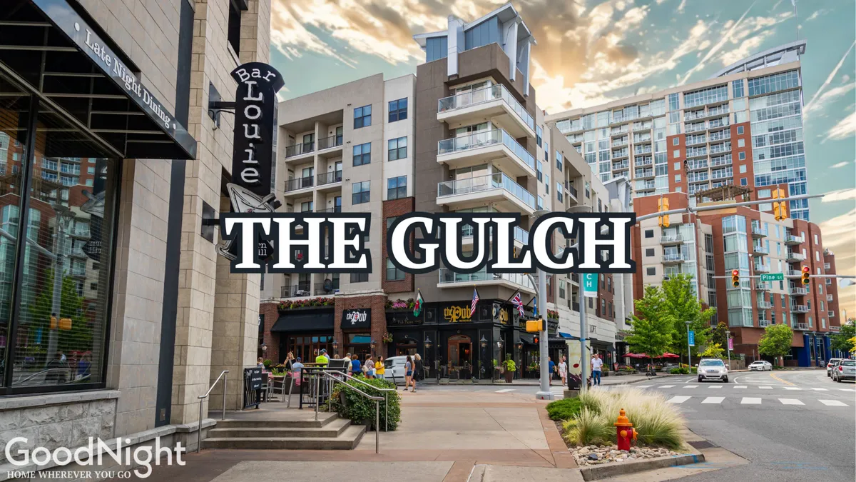 A lively streetscape featuring Bar Louie, mixed-use buildings, and bustling pedestrian activity. Outdoor café seating and visible street signs evoke the energy and walkability of the surrounding Midtown neighborhood, inviting guests to explore dining and nightlife options just steps away.